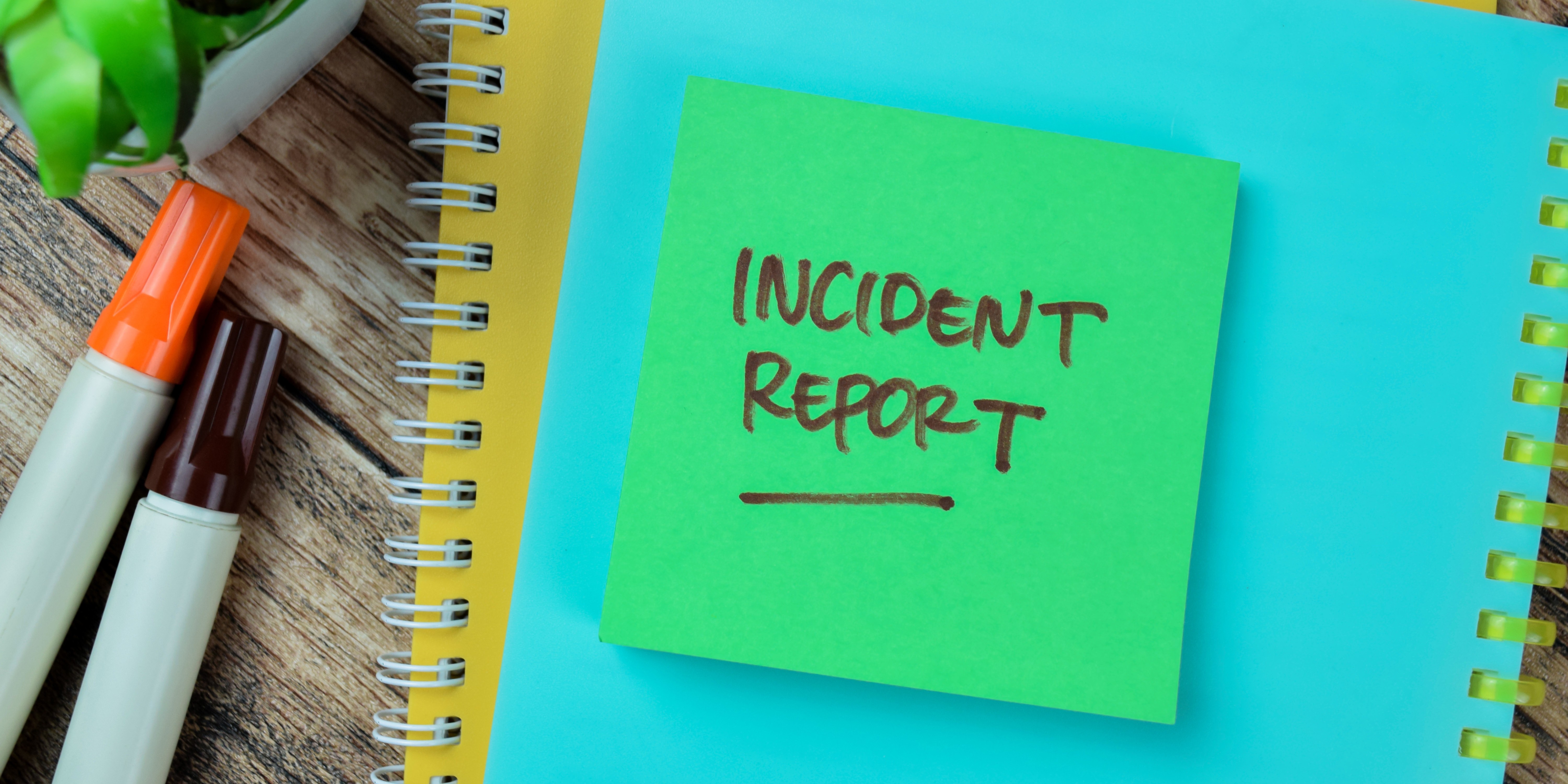 A sticky note on top of notebooks that says "Incident Report"