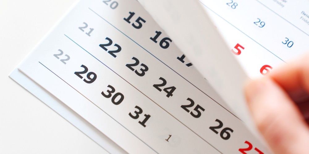 A person looking at a calendar for deadlines.
