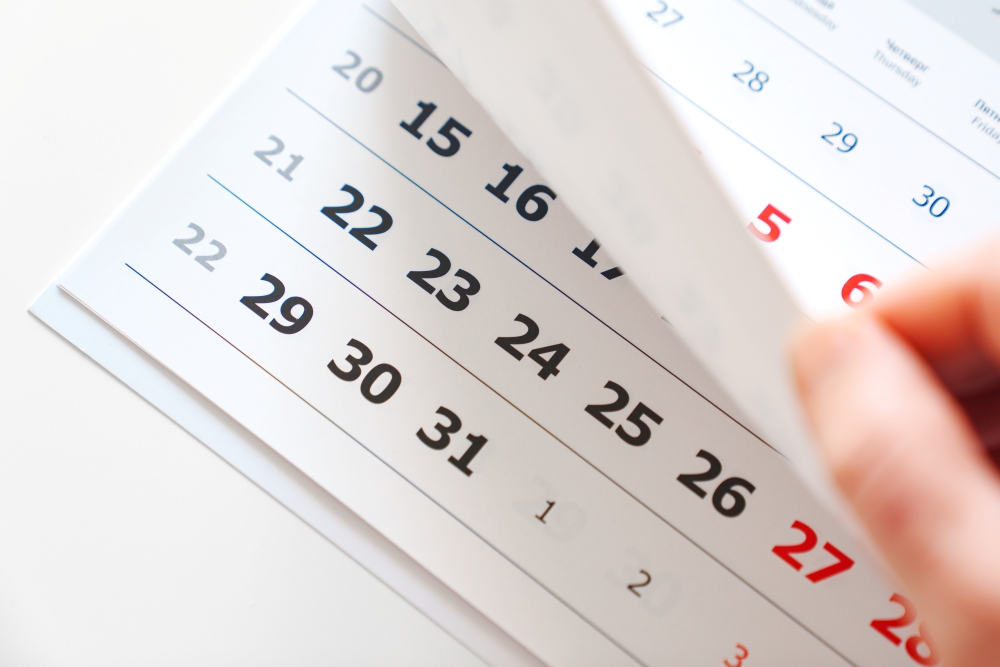 Close-up of a calendar page being turned, showing dates.